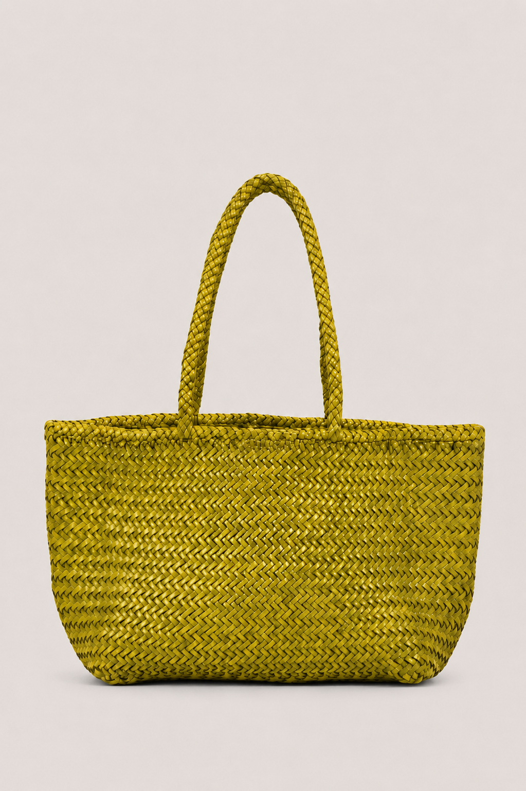 A woven straw tote bag in a vibrant olive yellow-green color, featuring two thick braided shoulder straps, set against a solid light gray background.